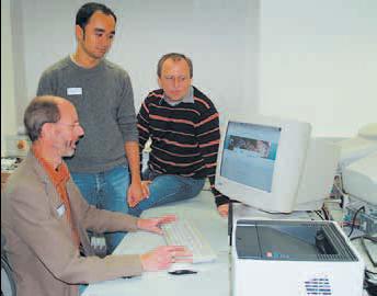 Drei Männer vor einem weißen CRT-Computerbildschirm und Tastatur aus Kunststoff, beige und grau